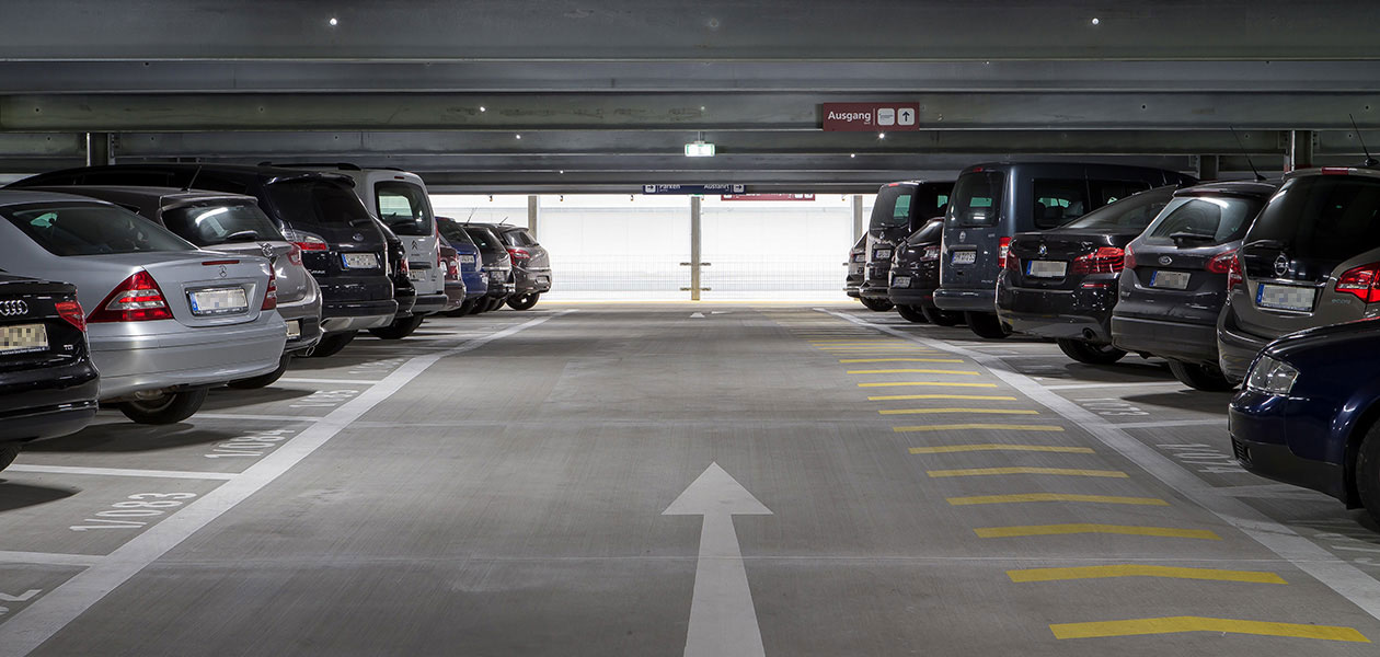 Gasse im Parkhaus mit parkenden Autos links und rechts